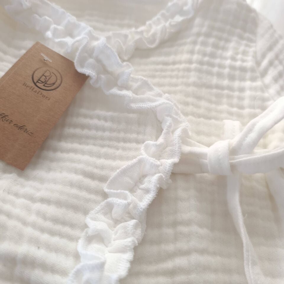 Ensemble de maternité quatre pièces en mousseline pour bébé fille, orné de volants.